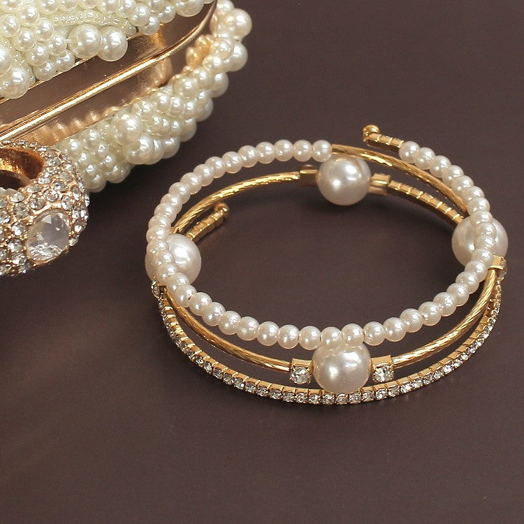 Triple-layered pearl and crystal cuff bracelet in gold and silver — stacked bangle design with rhinestones and faux pearls