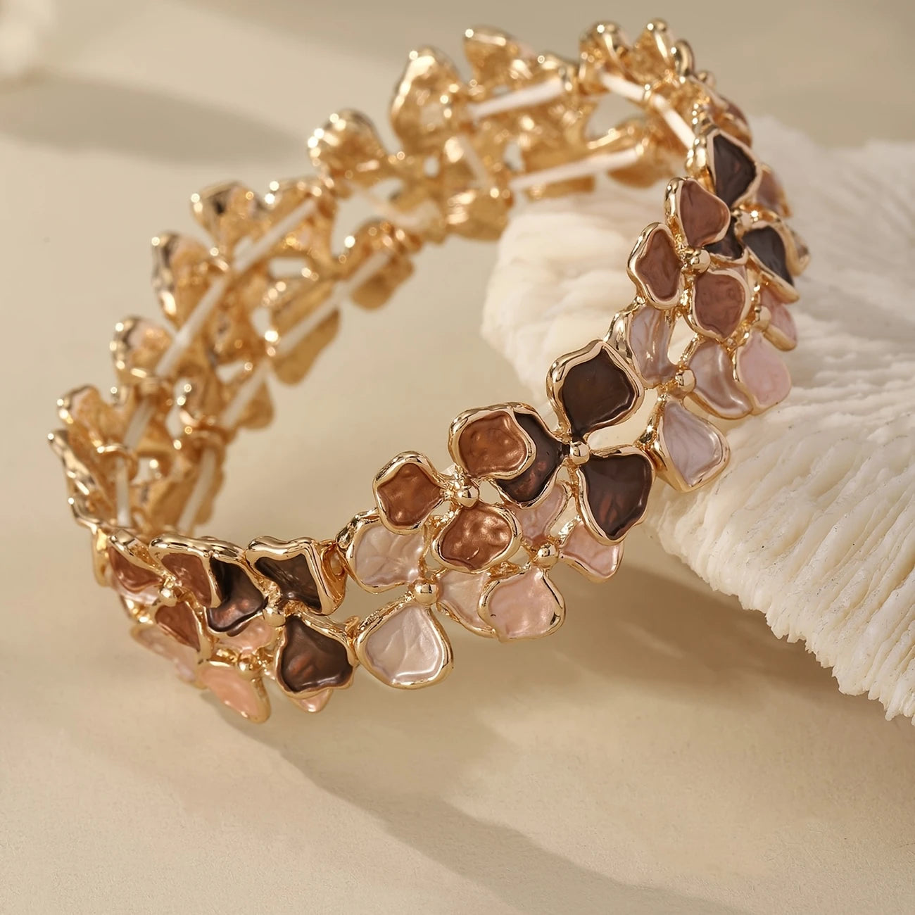 Elastic gold bangle with pastel enamel floral motifs in mauve, blush, and taupe – feminine stretch bracelet for women