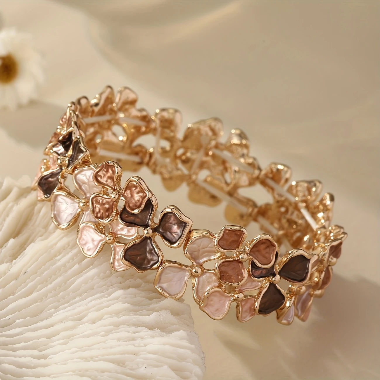 Elastic gold bangle with pastel enamel floral motifs in mauve, blush, and taupe – feminine stretch bracelet for women