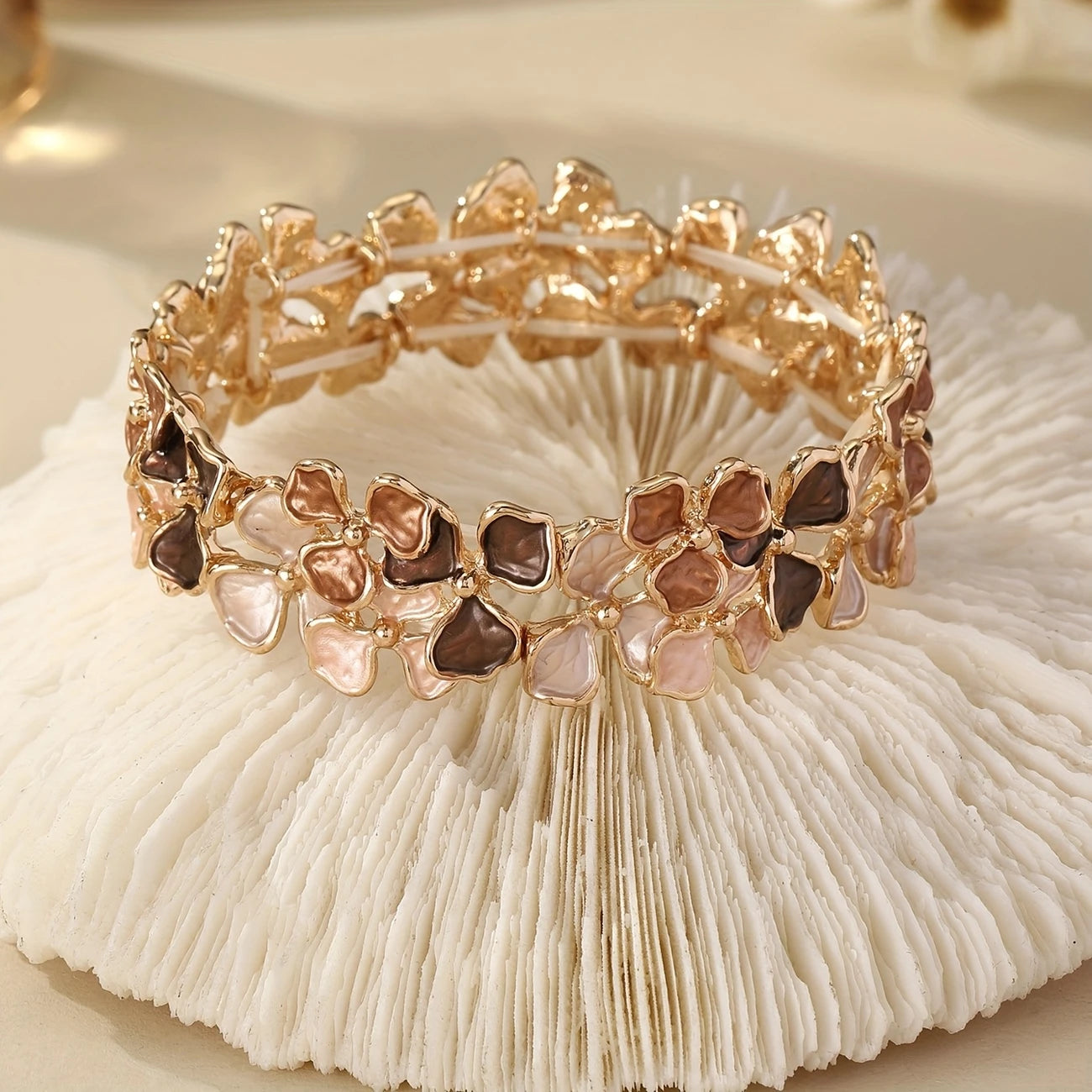 Elastic gold bangle with pastel enamel floral motifs in mauve, blush, and taupe – feminine stretch bracelet for women