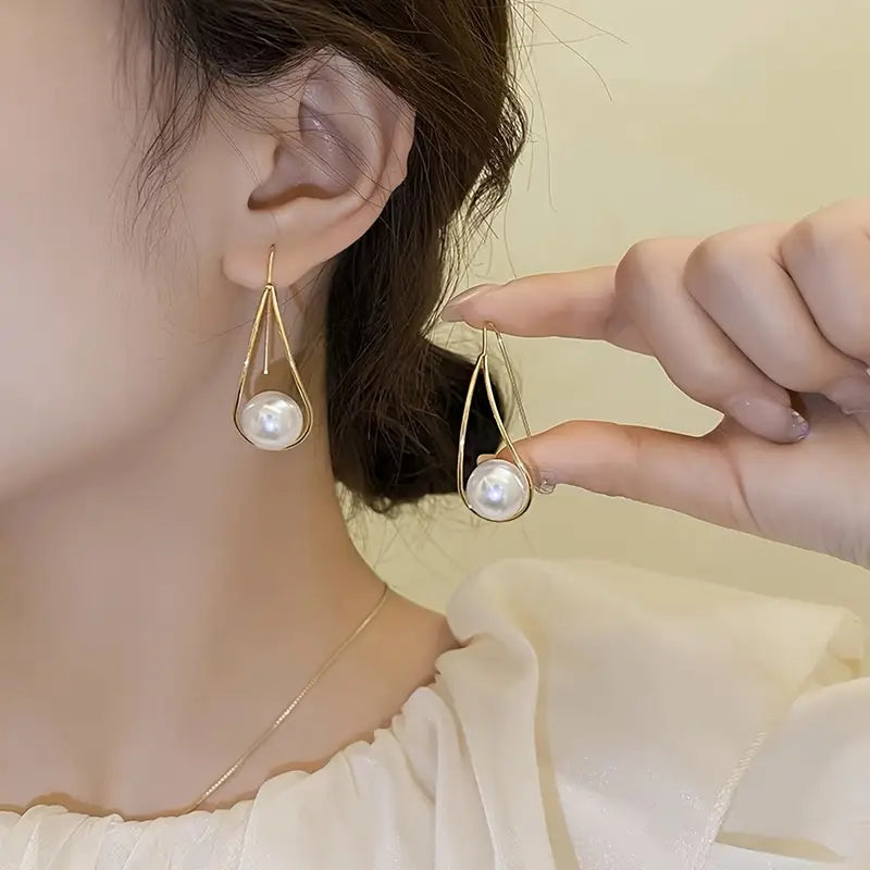 Minimalist teardrop earrings with suspended pearl bead in gold-tone frame – lightweight modern jewelry for women