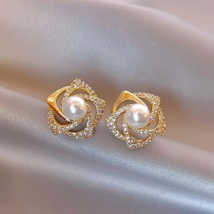 Gold floral swirl stud earrings with pave crystals and a central faux pearl – elegant feminine jewelry for formal occasions