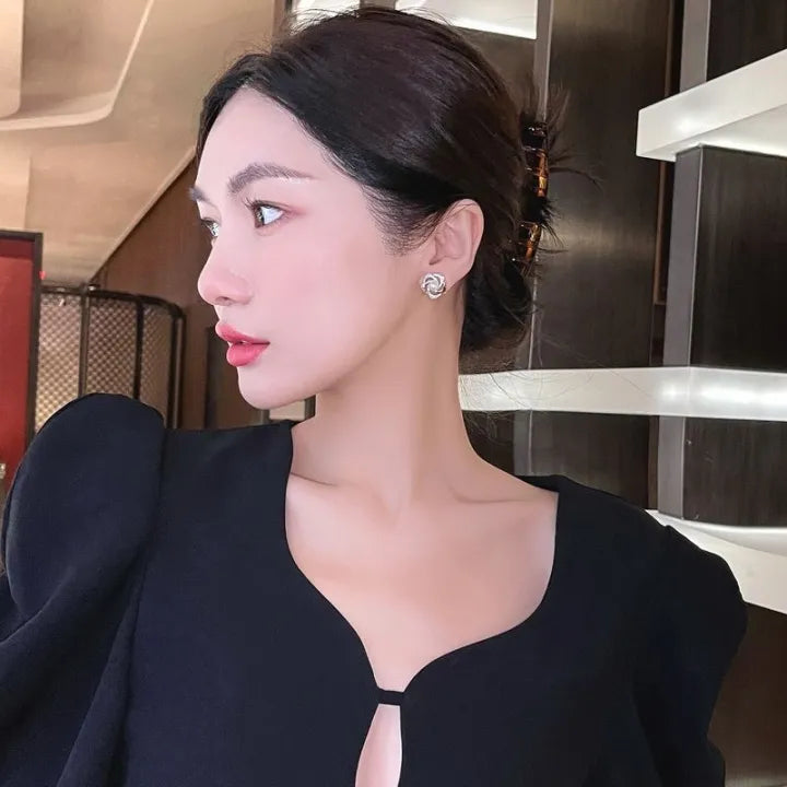 Gold floral swirl stud earrings with pave crystals and a central faux pearl – elegant feminine jewelry for formal occasions