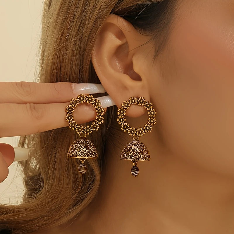 Antique gold floral jhumka earrings with circular flower top and bell-shaped drop – traditional desi jewelry for women