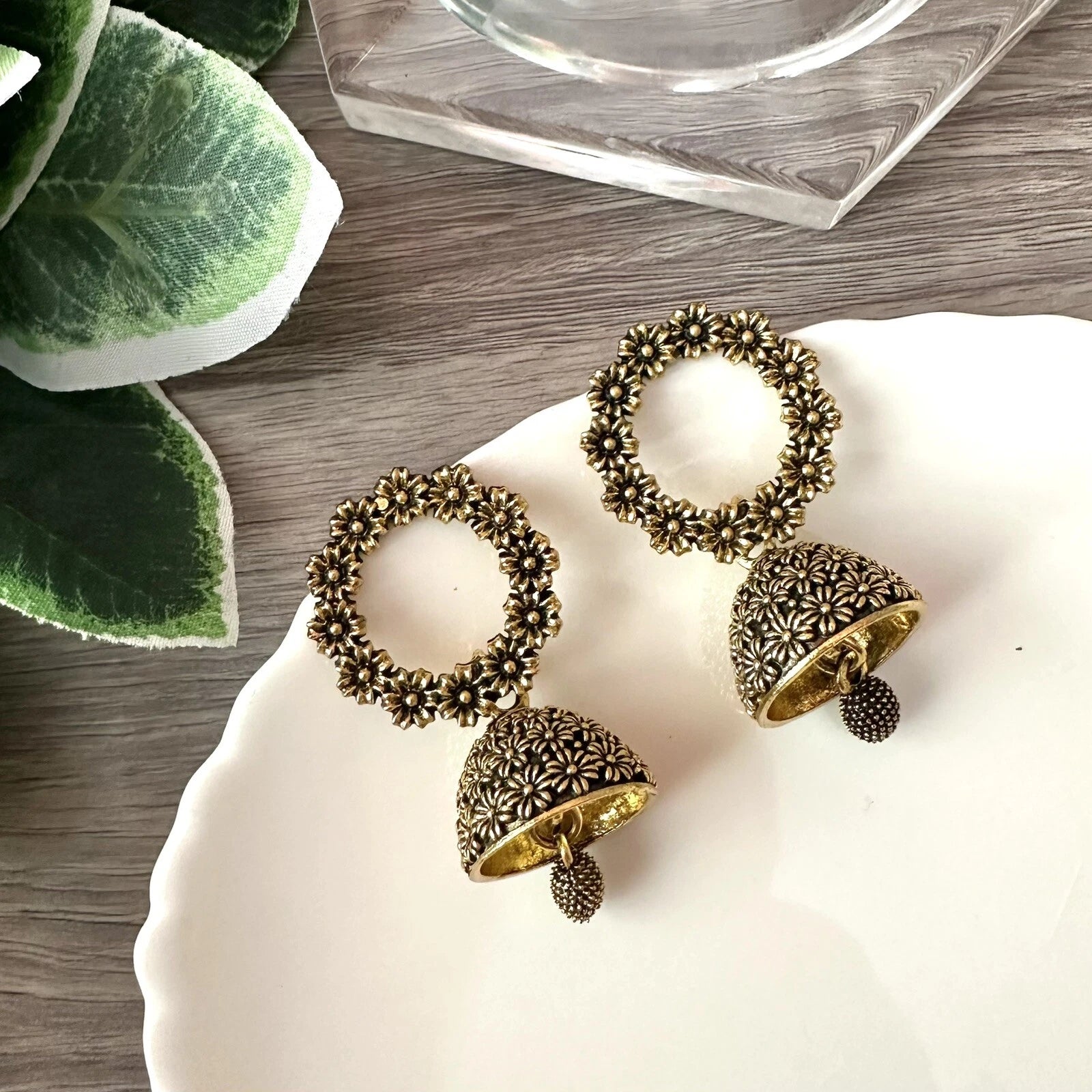 Antique gold floral jhumka earrings with circular flower top and bell-shaped drop – traditional desi jewelry for women